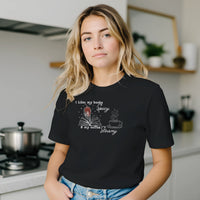 Load image into Gallery viewer, Woman wearing a premium side-seamed graphic tee featuring a vintage book and coffee cup aesthetic. An effortless everyday uniform for the modern minimalist."