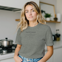 Load image into Gallery viewer, Blonde woman in a modern kitchen wearing the Heather Gray 'Hopeful Romantic' sueded cotton tee. Minimalist wellness apparel for everyday comfort.