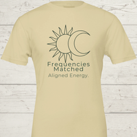 Load image into Gallery viewer, Flat lay of the Frequencies Matched tee in Earth tones ( Natural, Mauve, Grey, Clay), showcasing the minimalist "Aligned Energy" typography.