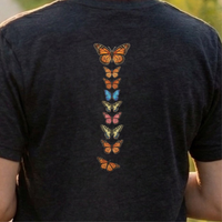 Load image into Gallery viewer, No. 26: Chrysalis to Flight - Detailed back view of a charcoal premium luxury tee featuring a high-contrast vertical butterfly spine graphic.