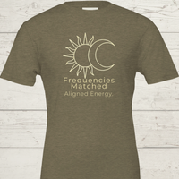 Load image into Gallery viewer, Flat lay of the Frequencies Matched tee in Earth tones ( Natural, Mauve, Grey, Clay, Heather Green), showcasing the minimalist "Aligned Energy" typography.