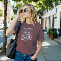 Load image into Gallery viewer, Woman wearing the heather mauve Akiramenai graphic tee styled with sunglasses and a shoulder bag in a sunny urban street setting.