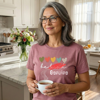 Load image into Gallery viewer, Mature woman wearing mauve Genuine t-shirt with Be Kind scratched out graphic. Vital Threads Study No. 18.