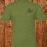 Load image into Gallery viewer, Dual Print Green t-shirt with a shamrock with interwoven Celtic knot design on a wooden background