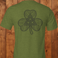 Load image into Gallery viewer, Dual Print Green t-shirt with a shamrock with interwoven Celtic knot design on a wooden background
