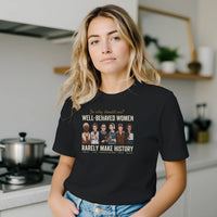Load image into Gallery viewer, A young woman leaning casually in a bright modern kitchen, wearing the black No. 32 Well-Behaved Women graphic t-shirt.