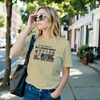 Load image into Gallery viewer, A young blonde woman wearing sunglasses walking down a city street, modeling the cream No. 32 Well-Behaved Women t-shirt by Vital Threads.
