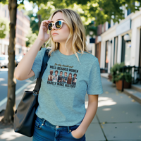 Load image into Gallery viewer, A young blonde woman wearing sunglasses walking down a city street, modeling the slate blue No. 32 Well-Behaved Women t-shirt.