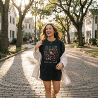 Load image into Gallery viewer, All Is Well shirt in Vintage Black — street lifestyle, cobblestone street scene