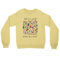 Load image into Gallery viewer, French Vanilla All Is Well crewneck sweatshirt laid flat, showing the wildflower field with “All is well” above and “With my soul” below in charcoal lettering.