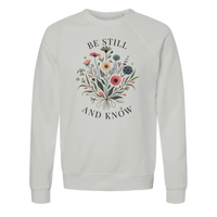 Load image into Gallery viewer, Ash Be Still and Know crewneck sweatshirt laid flat, showing the wildflower bouquet with "Be Still" above and "And Know" below in charcoal lettering.
