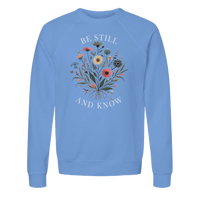 Load image into Gallery viewer, Carolina Blue Be Still and Know crewneck sweatshirt laid flat, showing the wildflower bouquet with "Be Still" above and "And Know" below in white lettering.

