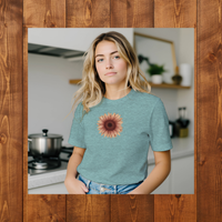 Load image into Gallery viewer, Kitchen (Framed) Heather Ice Blue: A blonde woman in a bright modern kitchen wearing the No. 28 The Evolution Premium Luxury Tee in Heather Ice Blue, showcasing an everyday mindful uniform.