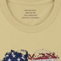 Load image into Gallery viewer, Close-up of the inner collar on the Soft Cream Deep Roots, Steady Heart shirt, showing the hidden message: Mine by birth. Mine for life. Not a statement, just how I was raised.