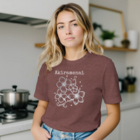 Load image into Gallery viewer, Female model with blonde hair standing in a bright kitchen wearing the heather mauve Vital Threads Akiramenai t-shirt.