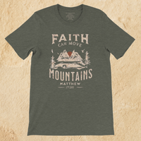 Load image into Gallery viewer, Flat lay of the Heather Military Green Faith can Move Mountains shirt on a tan background, showing the full front mountain graphic.