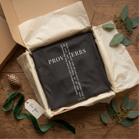 Load image into Gallery viewer, Folded Vintage Black He Will Straighten Your Path shirt displayed in an open kraft gift box with tissue paper and ribbon.