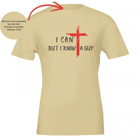 Load image into Gallery viewer, Soft Cream I Can't But I Know A Guy t-shirt, charcoal hand-brushed lettering, I CAN' over BUT I KNOW A GUY, with a red brushstroke cross that forms the T in CAN'T and stands between KNOW and A GUY, with the Matthew 19:26 collar verse shown inset.
