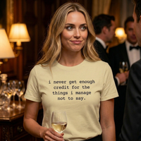 Load image into Gallery viewer, I never get enough credit shirt in Soft Cream — woman at formal event with knowing sideways glance, ultra-soft side-seamed tee.