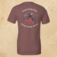 Load image into Gallery viewer, Back flat lay of the Land of the Free, Home of the Brave shirt in Heather Mauve, featuring an eagle gripping a spear-mounted flag with ‘Land of the Free’ and ‘Home of the Brave’ arched in Alabaster ink.