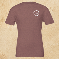 Load image into Gallery viewer, Front flat lay of the Land of the Free, Home of the Brave shirt in Heather Mauve, showing the 1776 star-circle badge on the left chest.