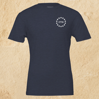 Load image into Gallery viewer, Front flat lay of the Land of the Free, Home of the Brave shirt in Heather Midnight Navy, showing the 1776 star-circle badge on the left chest.