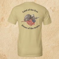Load image into Gallery viewer, Back flat lay of the Land of the Free, Home of the Brave shirt in Warm Cream, featuring an eagle gripping a spear-mounted flag with ‘Land of the Free’ and ‘Home of the Brave’ arched in Deep Espresso ink.