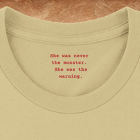 Load image into Gallery viewer, Warm Cream collar folded open showing She was never the monster She was the warning in red typewriter text