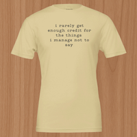 Load image into Gallery viewer, Flat lay mockup of the No 29 Unspoken Word premium sueded cotton tee in cream.