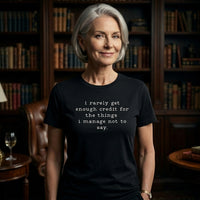 Load image into Gallery viewer, Distinguished woman in a curated library wearing the No 29 Unspoken Word minimalist graphic tee in vintage black. A quiet luxury aesthetic.