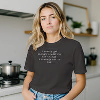 Load image into Gallery viewer, Woman in a bright kitchen setting wearing the No 29 Unspoken Word minimalist tee in dark charcoal.