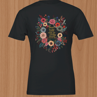 Load image into Gallery viewer, A flatlay presentation of the No. 33 The Calling premium luxury tee in black, displaying the crisp Proverbs 3:5 bronze typography framed by a high-contrast vintage botanical wreath.