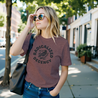 Load image into Gallery viewer, A woman in sunglasses wearing the No. 35 Radicalized By Basic Decency shirt in Heather Mauve — archival crow stamp as a wearable statement for those committed to treating people right.