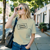 Load image into Gallery viewer, A woman walking outdoors in sunglasses wearing the Perfectly Imperfect off-axis graphic tee in cream by Vital Threads.