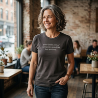 Load image into Gallery viewer, Silver-haired woman in a café — Your Little Ray of Sarcastic Sunshine Has Arrived Vintage Black premium graphic tee by Vital Threads.