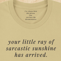 Load image into Gallery viewer, Inner back collar of the warm cream tee reading "I've always been this person. Now you have the documentation." — Vital Threads hidden manifesto detail.