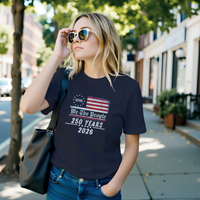 Load image into Gallery viewer, Effortless everyday style featuring the premium Semiquincentennial 2026 tee in Heather Midnight Navy, styled with a leather tote and sunglasses to project quiet authority and vitality in motion.