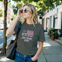 Load image into Gallery viewer, Modern minimalist woman walking outdoors in the Heather Military Green We The People 250th anniversary shirt, highlighting the uncompromising comfort and high-contrast vintage Americana aesthetic.