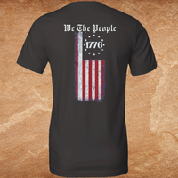 Load image into Gallery viewer, Close flat lay of the We The People premium tee back graphic in vintage black, distressed American flag and gothic We The People typography on premium ring-spun cotton