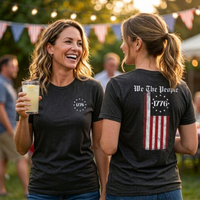 Load image into Gallery viewer, Cropped lifestyle shot of two women in vintage black We The People premium tees at a Fourth of July backyard party under string lights
