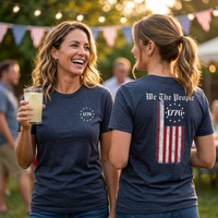 Load image into Gallery viewer, Two women at a Fourth of July backyard party wearing the We The People premium tee in heather midnight navy, showing the 1776 Betsy Ross star circle chest graphic and We The People distressed flag back graphic