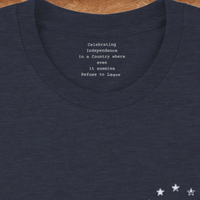 Load image into Gallery viewer, Inside collar of the We The People premium tee revealing the hidden typewriter-font message: Celebrating Independence in a Country where even its enemies Refuse to Leave