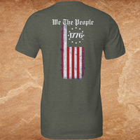 Load image into Gallery viewer, Flat lay back view of the We The People premium tee in olive showing the We The People gothic blackletter headline and distressed vertical American flag with 1776 star circle detail