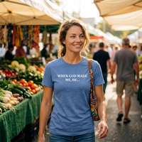 Load image into Gallery viewer, Woman carrying a tote bag at an outdoor farmers market wearing the When God Made Me shirt in Heather Columbia Blue, front "When God Made Me, He..." text visible.